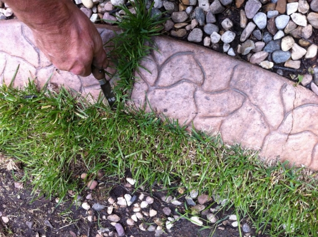 use a hooked knife to get grass out of gaps