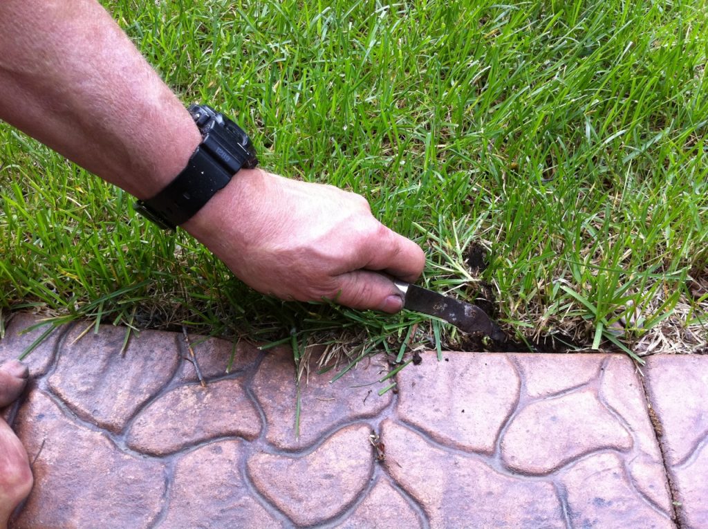 Use a hooked knife for edging the grass back a bit from the curb